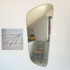 an image of a chair in the corner of a room with a mirror on the wall