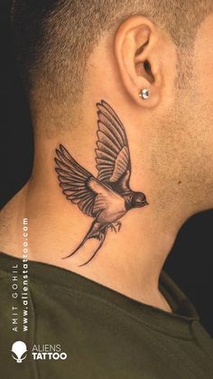 a man's neck with a bird tattoo on the back of his neck,