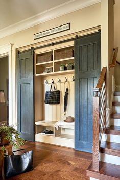 an entryway with wooden floors and open doors leading to the second floor is shown