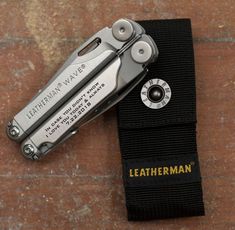 a pair of leatherman knifes sitting on top of a black cloth covered case