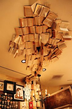 a room filled with lots of books floating from the ceiling