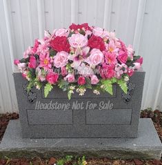 a grave with pink and red flowers in it