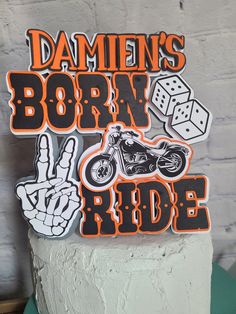 a cake that has some stickers on it and is decorated with the words born to ride