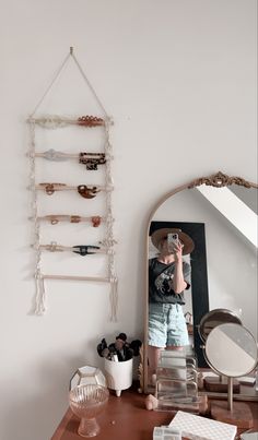 a woman taking a selfie in front of a mirror on top of a dresser