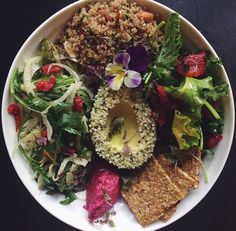 a white bowl filled with lots of different types of food on top of a table