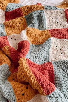 a crocheted blanket is laying on top of a bed