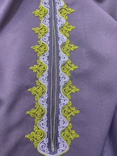 an embroidered purple shirt with yellow and white designs on the front, along with green trim