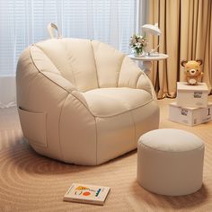 a white chair and ottoman in a living room with a teddy bear on the floor