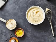 three bowls filled with different types of mayonnaise and other condiments on a table