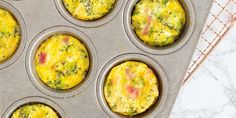 several muffins with different toppings in a metal pan on a marble counter