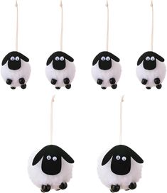 four sheep ornaments hanging from strings with eyes drawn on them, all in black and white