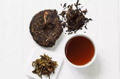 an assortment of teas and pastries on a white surface with a cup of tea