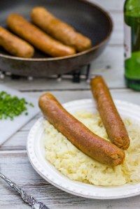 two sausages are on top of rice in front of a frying pan with other food items