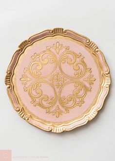 a pink and gold plate sitting on top of a white table