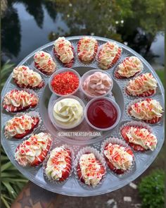 cupcakes with white frosting and red sprinkles on a plate