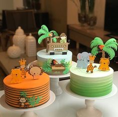 three tiered cakes decorated with jungle animals and giraffes are on display