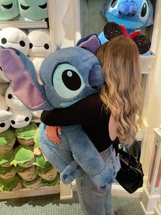 a woman is hugging an elephant stuffed animal