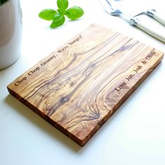 a wooden cutting board sitting on top of a table next to a knife and fork