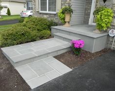 a house with steps leading up to the front door and flower pots on either side