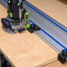 a machine that is cutting wood with a green and black tool on it's side