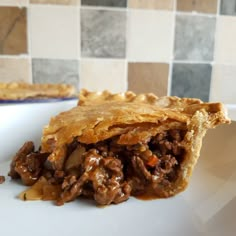 a piece of meat pie sitting on top of a white plate