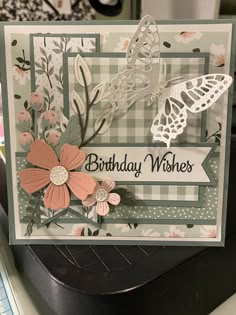 a close up of a birthday card on a table with flowers and butterflies in the background