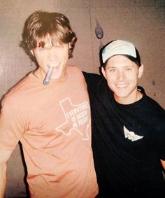 two young men standing next to each other with a toothbrush in their mouth and one is brushing his teeth