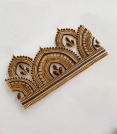 an intricately designed gold broochle on a white surface