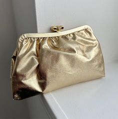 - Vintage Gold Lamé Clutch - Gorgeous metallic gold color - Envelope Clutch with gold hardware (bow) - Measures: 8.5" x 5.5" - Ships free, with tracking, within the United States >> International buyers: Please contact us for a shipping quote before purchase! We do offer international shipping, but don't want to over/undercharge our buyers. Any international purchase with free shipping attached with be automatically cancelled and refunded. Thank you! - Love it and want to buy later? Click on the Clutch Prom, Gold Clutch Purse, Prom Purse, Metallic Gold Color, Gold Lame, Gold Clutch, Bridal Clutch, Vintage Clutch, Purse Vintage