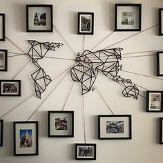 a world map made out of many framed photos on a wall with black and white frames