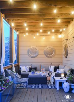 an outdoor living area with patio furniture and string lights on the ceiling, along with potted plants