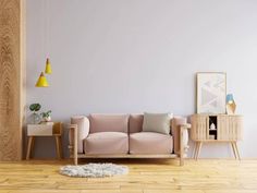 a living room with a pink couch and two yellow lamps