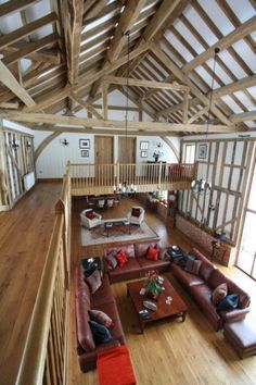 a living room filled with lots of furniture and wooden beams on top of the ceiling