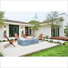 an outdoor living area with chairs, fire pit and patio furniture in front of a house