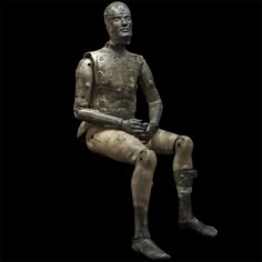 a bronze statue sitting on top of a black background