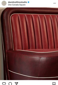 a red leather chair sitting on top of a wooden floor