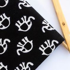 a pair of scissors sitting next to a black and white cloth with hand prints on it