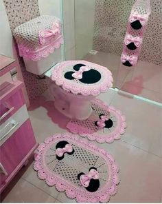 a pink bathroom with minnie mouse rugs on the floor