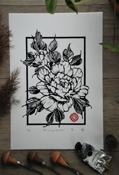 a flower is shown in black and white on a piece of paper next to some crafting supplies