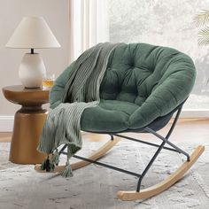 a rocking chair with a blanket on it in front of a lamp and window sill