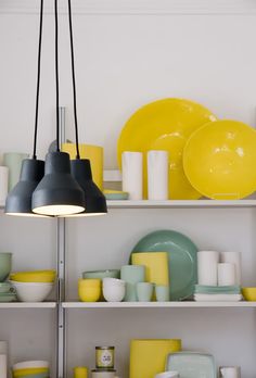 the shelves are filled with yellow and blue dishes