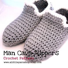 a pair of crocheted gray slippers with white trim