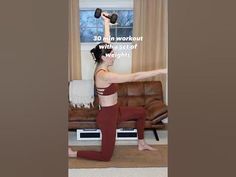 a woman is doing exercises with dumbbells in her living room while looking out the window