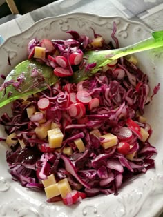 a white bowl filled with red cabbage and diced cheese on top of a table