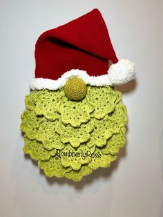 a crocheted santa hat hanging on the wall