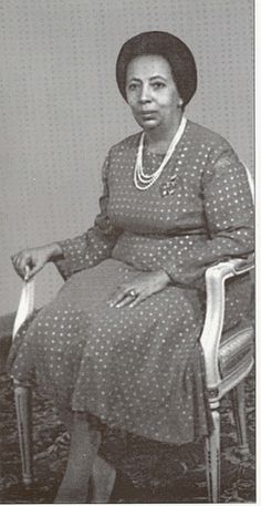 an old photo of a woman sitting in a chair