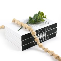 a string of wood beads is attached to a book that reads execute grand fistle