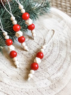 some red and white beads are hanging from a christmas tree ornament on a plate