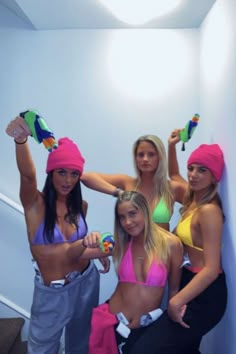 four women in bathing suits posing for the camera with their hands on their hipss