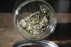 a glass jar filled with white stuff on top of a wooden table next to a metal container